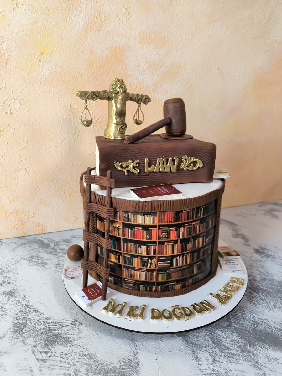 Kitaplık görünümlü, üzerinde LAW yazılı kitap, altın adalet terazisi ve tokmak figürleri olan hukuk temalı doğum günü pastası