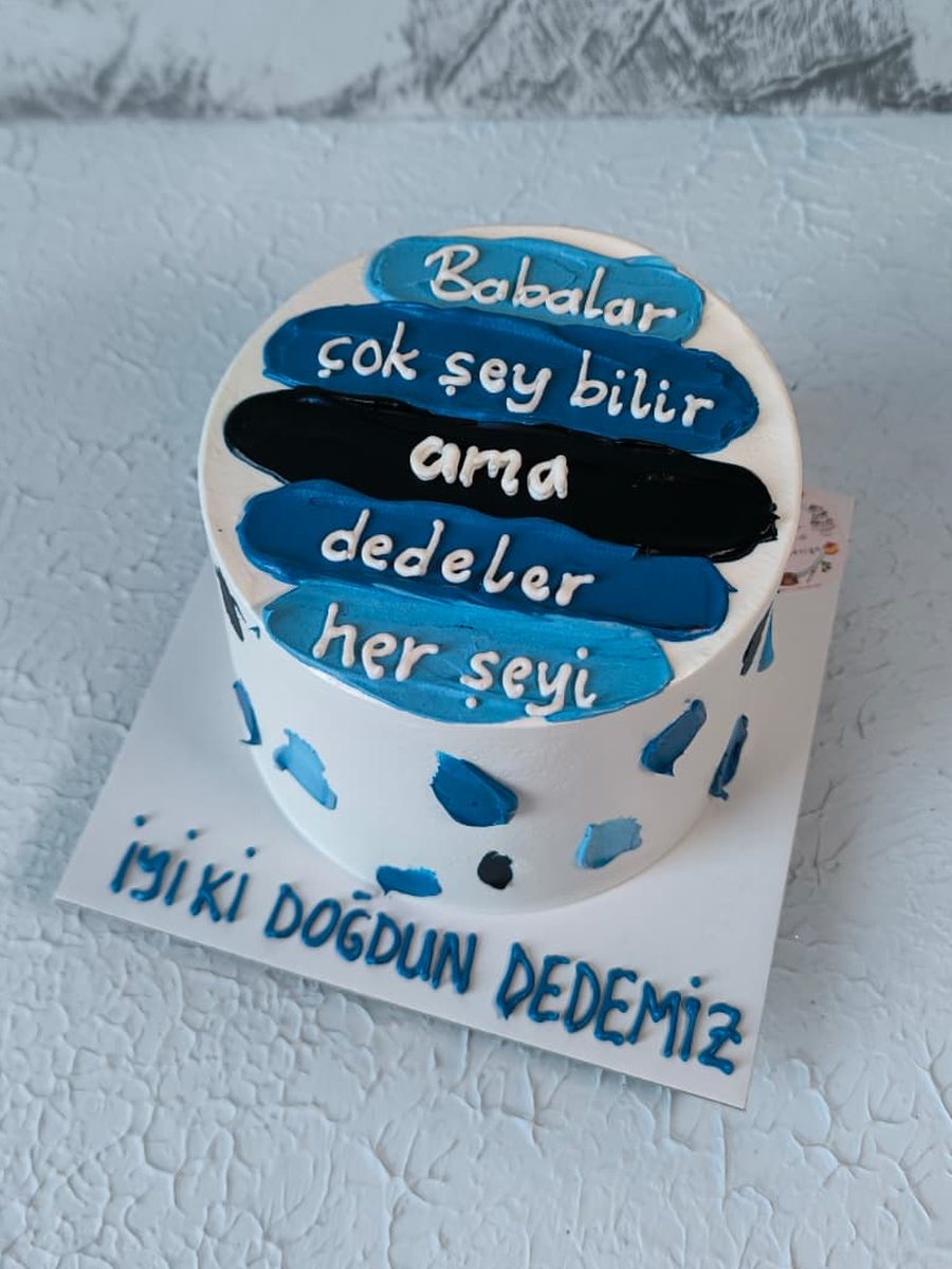 Mavi ve siyah krema şeritleri üzerine 'Babalar çok şey bilir ama dedeler her şeyi' yazan, tabağında 'İyi ki doğdun dedemiz' yazan pasta